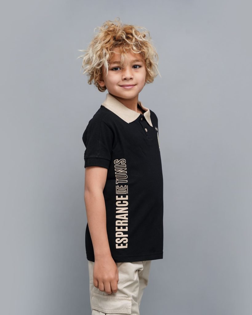 Jeune garçon portant le Polo Junior Espérance Tunis – coloris noir avec texte vertical